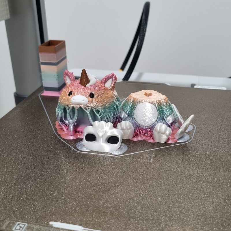 Conjunto de miniaturas coloridas impressas em 3D, agrupadas sobre uma bandeja